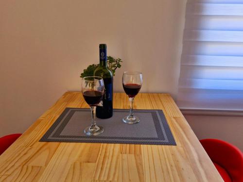 a table with a bottle of wine and two glasses at Entre Quebradas y Loicas in Algarrobo
