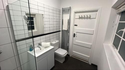 a white bathroom with a toilet and a sink at Hilston Park in Monmouth