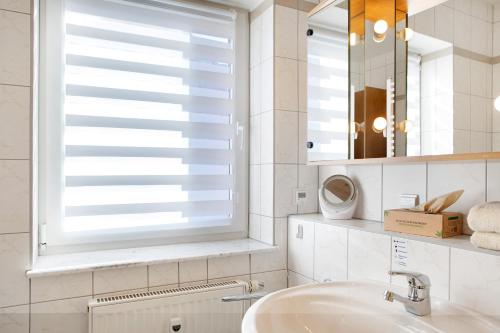 baño con lavabo y ventana con persianas en Ferienwohnung Tannenblick 7-4, en Oberhof