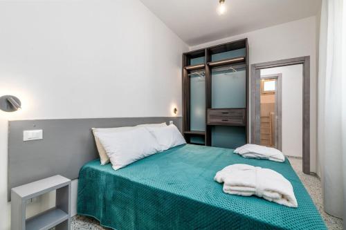 a bedroom with a green bed with towels on it at Villa Apeliote in Carovigno