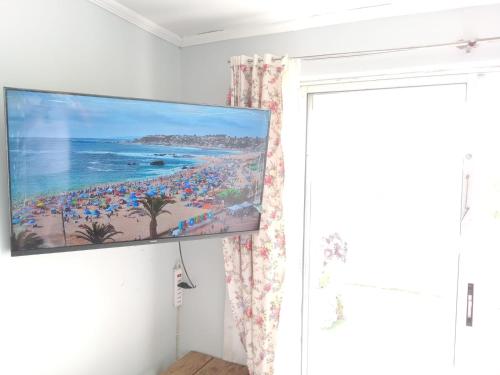 a flat screen tv hanging on a wall in a room at Cabañas Mirador de Soledad in El Quisco