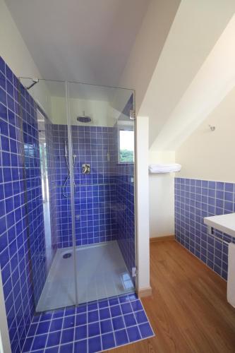 a bathroom with a shower with blue tiles at Hotel Giardino Suites&Spa in Numana