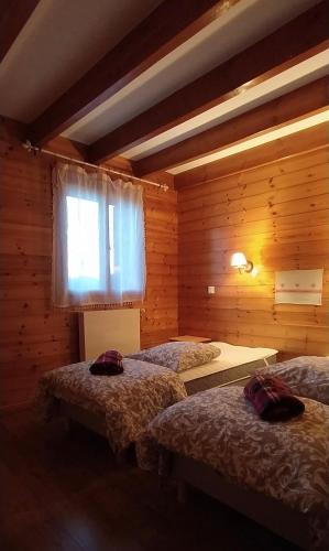 Un dormitorio con dos camas y una ventana. en Ecogite Mercantour Le Pacha, en Valdeblore