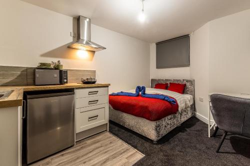 a small bedroom with a bed and a kitchen at Comfortable Stay - Derby Road in Nottingham
