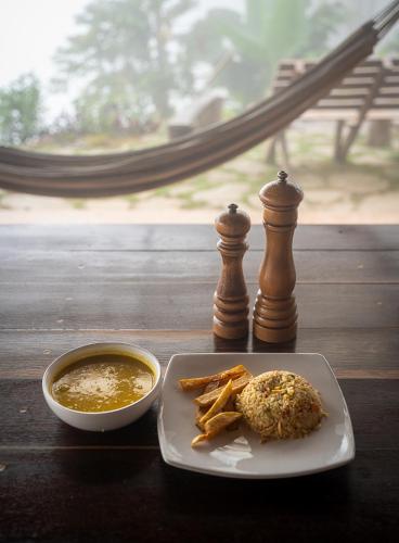 a table with a plate of food and a bowl of soup at Mano Verde Minca in Minca