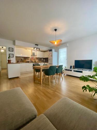 un salon avec une table et des chaises et une cuisine dans l'établissement Appartement spacieux et lumineux de 67 m2, 2 balcons, à Saint-Ouen