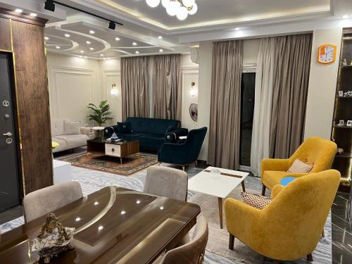 カイロにあるThe Royal Apartment at New Cairo الشقة الملكية بالقاهره الجديدةのソファと椅子のあるリビングルーム