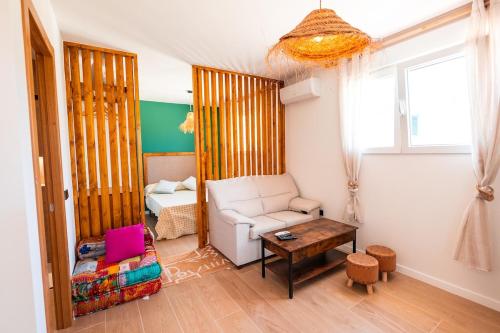 a living room with a white chair and a table at B - Studio Vista al Sol in Jávea