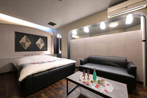 a bedroom with a bed and a couch and a table at Hotel NEO in Honjo