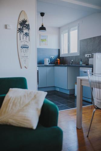 un salon avec un canapé vert et une cuisine dans l'établissement Le Côte Ouest - 2 Bedroom Apartment with Garage, à Dijon