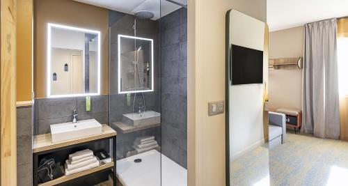 a bathroom with two sinks and a large mirror at Best Western Coeur de Maurienne Hotel Restaurant & Spa in Saint-Jean-de-Maurienne