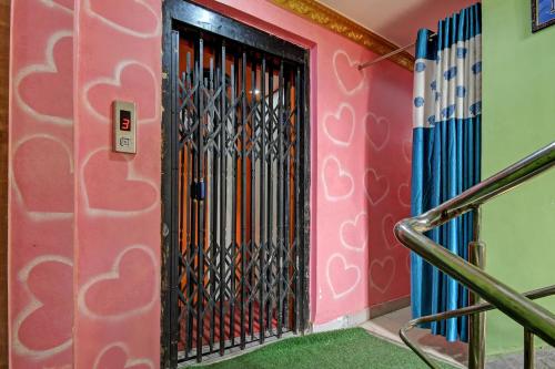 a black door in a pink wall with a staircase at Hotel O Star View in Kolkata