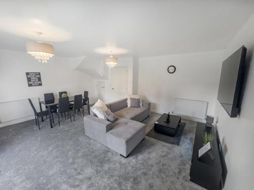 a living room with a couch and a table at Sleeps 8 with Garden and Pet Friendly in Ashford