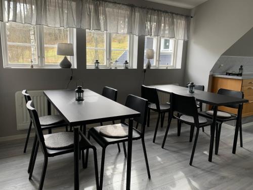 two tables and chairs in a room with windows at Hallamölla Gård in Brösarp