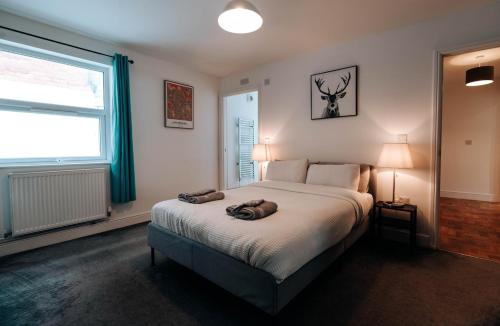 a bedroom with a bed with two towels on it at Prosper House Apartment 3 in Norwich