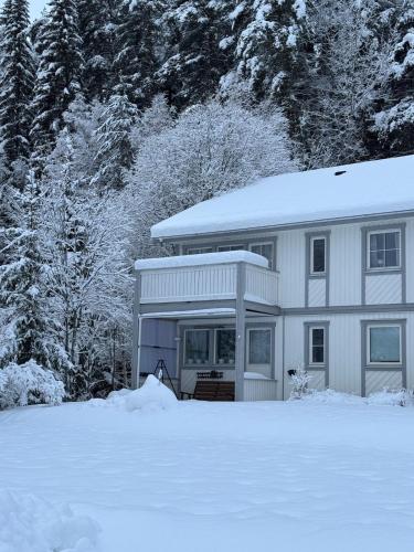 una casa bianca con la neve per terra di 2 Bedroom apartment close to Branäs Resort a Likenäs