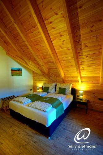 a large bed in a room with a wooden ceiling at Wood Apartments 4 Jahreszeiten in Landl