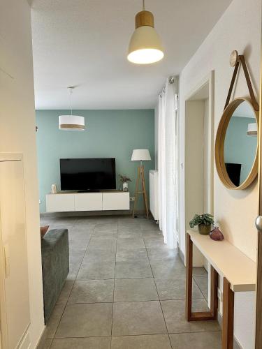 - un salon avec une télévision et un miroir dans l'établissement Chez Marie, à Entzheim