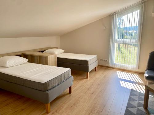 une petite chambre avec deux lits et une fenêtre dans l'établissement Appartement Duplex 3 chambres - La Blache des Collines, à Beausemblant