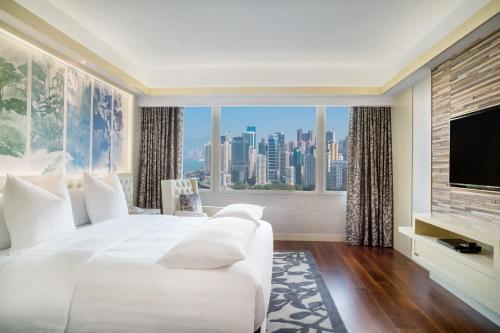 a bedroom with a large white bed and a large window at The Park Lane Hong Kong, Autograph Collection in Hong Kong