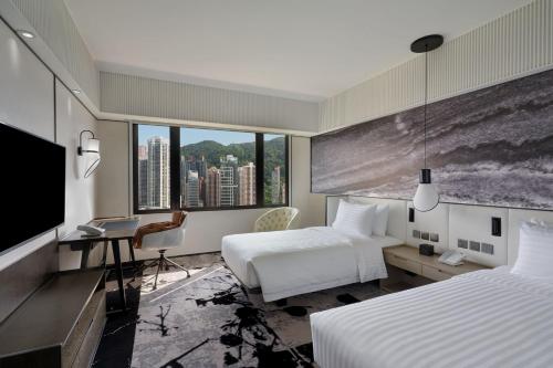 a hotel room with two beds and a flat screen tv at The Park Lane Hong Kong, Autograph Collection in Hong Kong