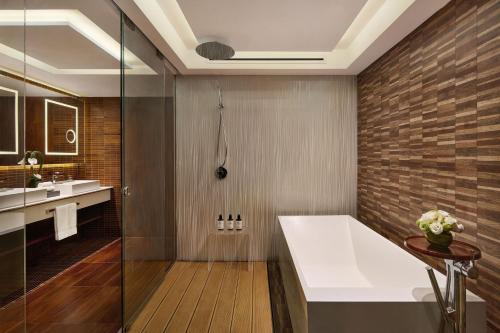 a bathroom with a bath tub and a sink at The Park Lane Hong Kong, Autograph Collection in Hong Kong