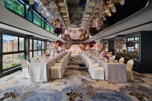 a long banquet hall with white tables and white chairs at The Park Lane Hong Kong, Autograph Collection in Hong Kong