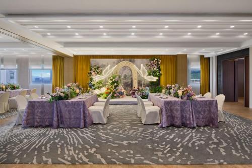 a banquet hall with tables and chairs and flowers at The Park Lane Hong Kong, Autograph Collection in Hong Kong