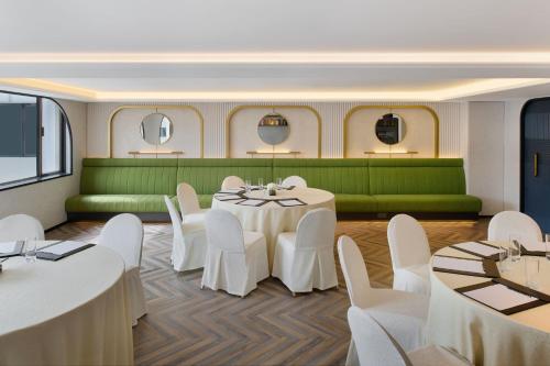 a banquet room with white tables and white chairs at The Park Lane Hong Kong, Autograph Collection in Hong Kong