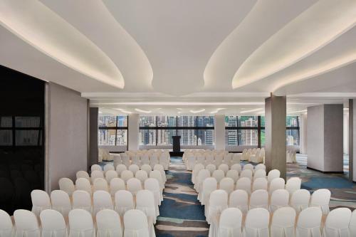 a conference room with white chairs and a podium at The Park Lane Hong Kong, Autograph Collection in Hong Kong