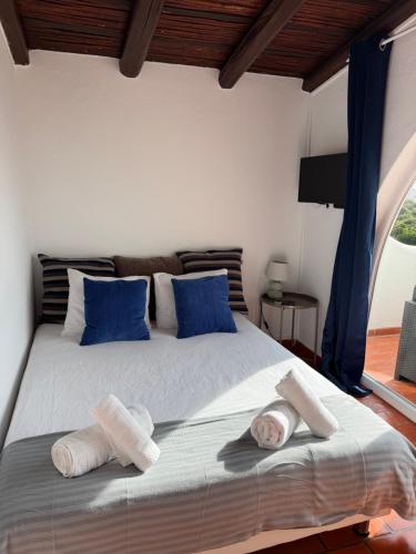 a bedroom with a large bed with blue pillows at Vila Horizonte in Carvoeiro