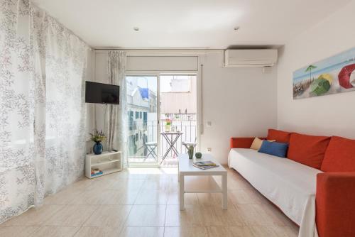 a living room with a couch and a table at Nova Apartment by Hello Homes Sitges in Sitges