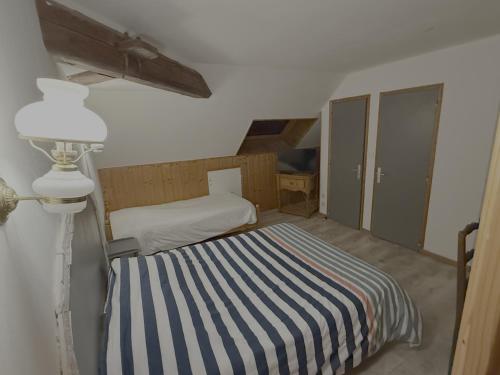 Cette petite chambre comprend un lit et une lampe. dans l'établissement Auberge du Comtois, à Pont-dʼHéry