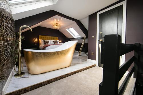 a bathroom with a tub in the middle of a bedroom at Serenity Suites in Whitby