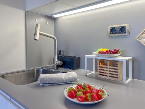 a kitchen with two bowls of fruit on a counter at Bleuets VI in Sainte-Léocadie