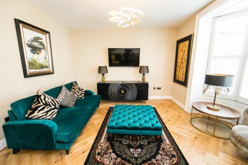 a living room with a green couch and a table at Serenity Suites in Whitby