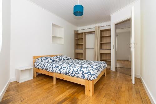 - une chambre avec un lit dans une pièce dotée d'étagères dans l'établissement Belle Maison Nancy avec 3 chambres individuelles, à Nancy