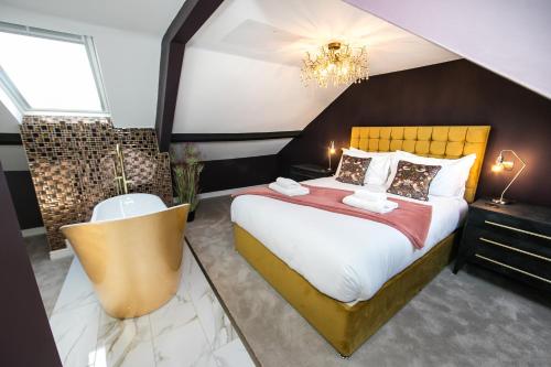 a bedroom with a large bed and a chandelier at Serenity Suites in Whitby