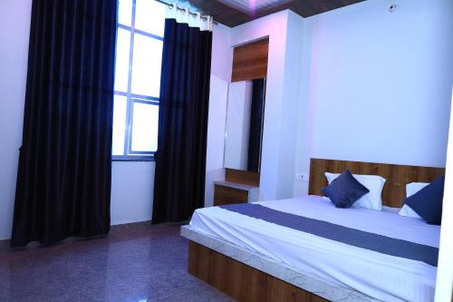 a bedroom with a bed and a large window at Hotel SHIV SHAKTI PALACE in Rīngas
