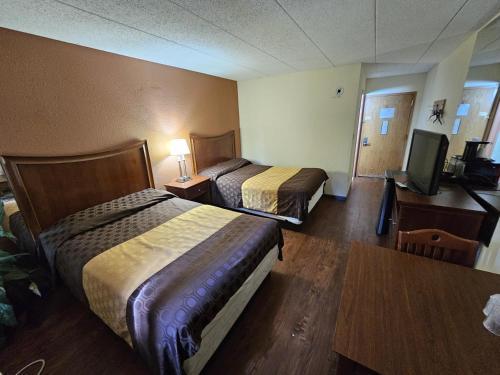 a hotel room with two beds and a flat screen tv at La Mirage in Monmouth Junction