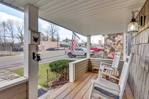 a porch with two chairs and an american flag at Near Murphy River Walk Historic Downtown Home! in Murphy