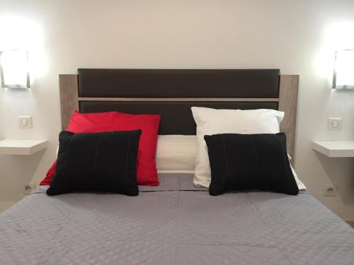 a bedroom with a bed with red and black pillows at Appartement Le Vieux Port in Marseille