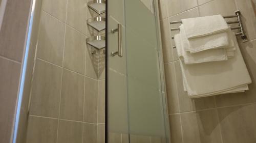 a shower with a glass door and towels in a bathroom at Appartement Le Vieux Port in Marseille