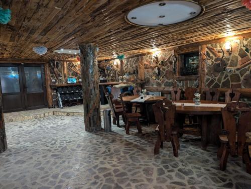 a restaurant with wooden walls and tables and chairs at Casa Letca montain in Sohodol