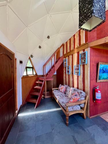 a living room with a couch and a staircase at Domo Huepil in Pichare