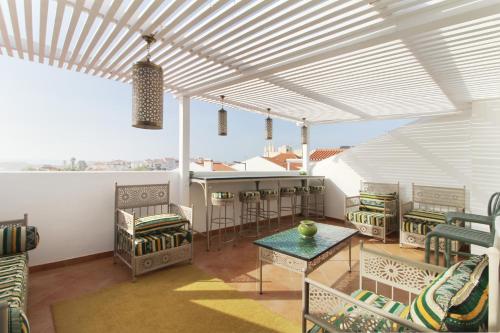 a room with chairs and a table and a counter at Casa Almira Vista Mar in Vila Nova de Milfontes