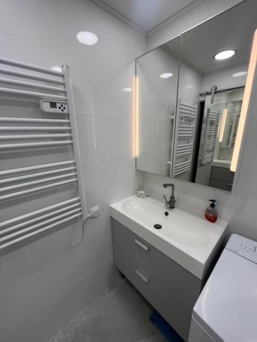 une salle de bain blanche avec un lavabo et un miroir dans l'établissement Antibes carré d'or Bastion Albert 1er Vue mer, à Antibes