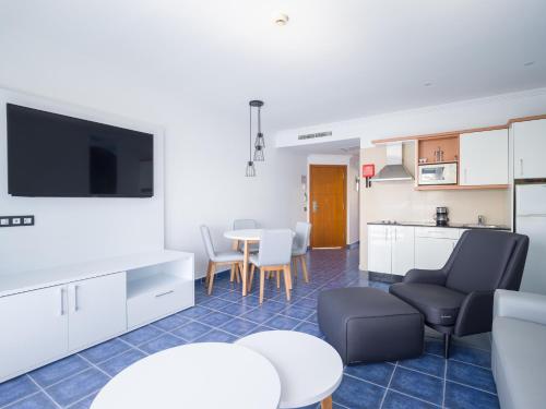 a living room with a kitchen and a table with chairs at Hotel Mirador Papagayo by LIVVO in Playa Blanca
