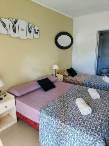 a bedroom with two beds and a mirror on the wall at La Balbina Casa Quinta Corrientes in Santa Ana