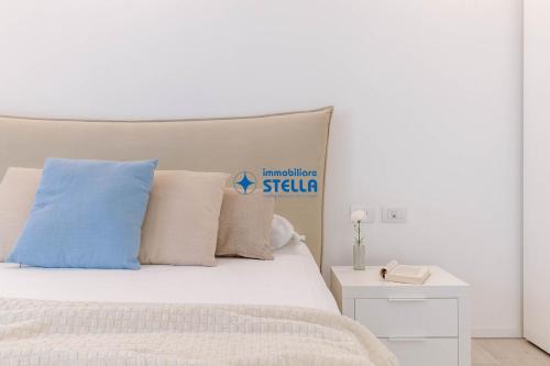 a white bed with pillows and a sign on it at Cala Blu in Lido di Jesolo